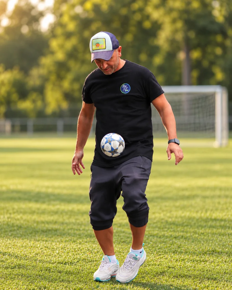 Fatih Yildirim im BeYou Shirt mit einem Fußball auf dem Trainingsplatz