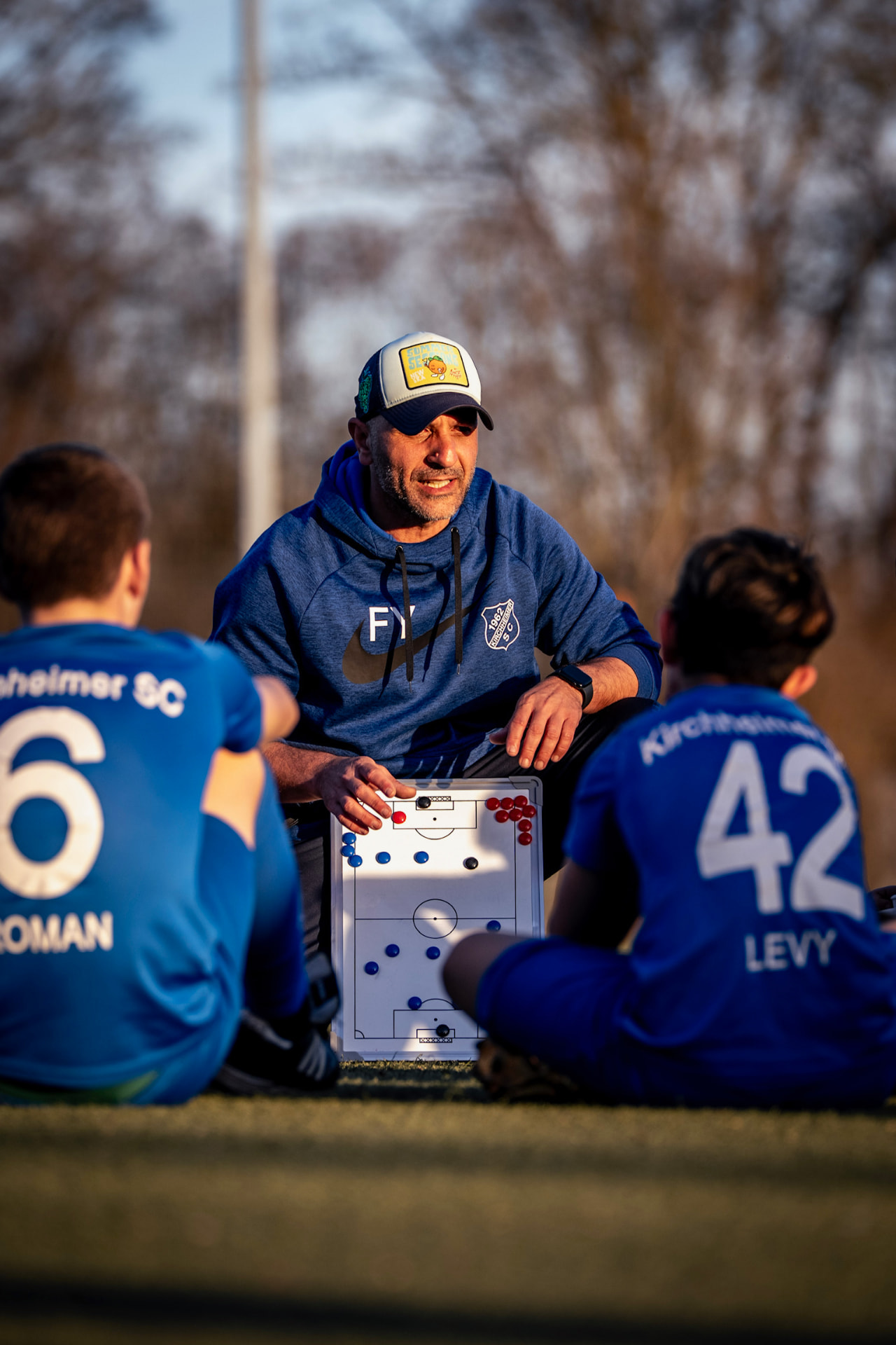 Fatih Yildirim erklärt zwei jungen Spielern eine Situation an der Taktiktafel